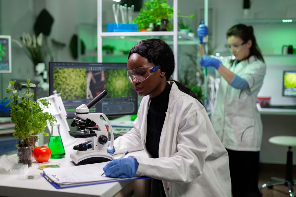 Two scientists wearing lab coats are working in a laboratory. 