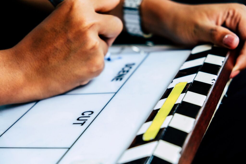 A close up captures a film slate with Scene and Cut printed on its surface.