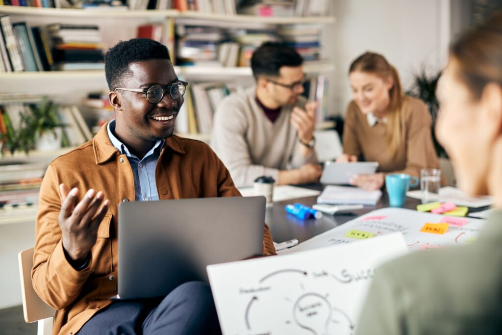 In a brightly lit workspace, four adults engage in a collaborative discussion.