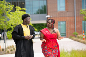 Two Student Government  Association representatives, one male, one female, walking together outside on campus.