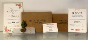 Wedding stationery suite featuring a floral-themed invitation, RSVP card, details card, envelopes, and a decorative wax seal. The design uses soft floral illustrations, elegant script typography, and neutral-toned paper materials.