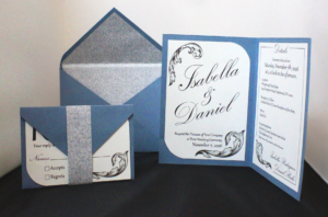 Custom wedding stationery suite featuring an invitation, RSVP card, details card, and coordinating envelopes. The design incorporates blue paper stock, decorative scrollwork, patterned envelope liners, and elegant script typography.